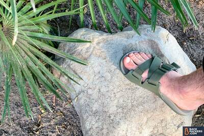 chaco chillos slide two feet on a rock