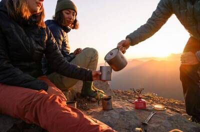 Friends enjoying a scenic sunset and a hot drink using the MSR Titanium Collection