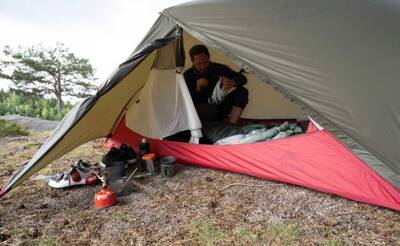 Man fixing his helmet inside the Hubba Hubba Bikepack Tent