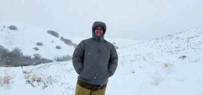 Man in Orvis Pro Insulated Hoodie in snow standing.