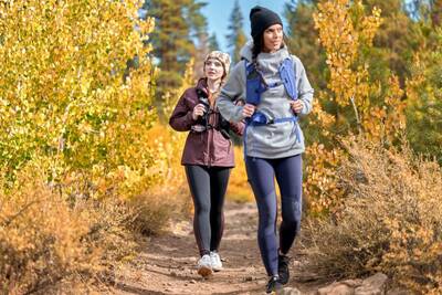 Women hiking through fall foliage wearing Active Threads